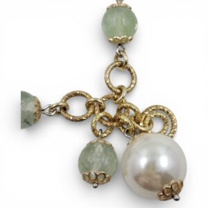 Bracciale artigianale in argento dorato con sfere di prenite verde chiaro, maglie intrecciate e una grande perla bianca pendente su fondo bianco.